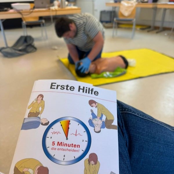 Flyer Erste-Hilfe Kurs und Beatmung an Puppe im Hintergrund