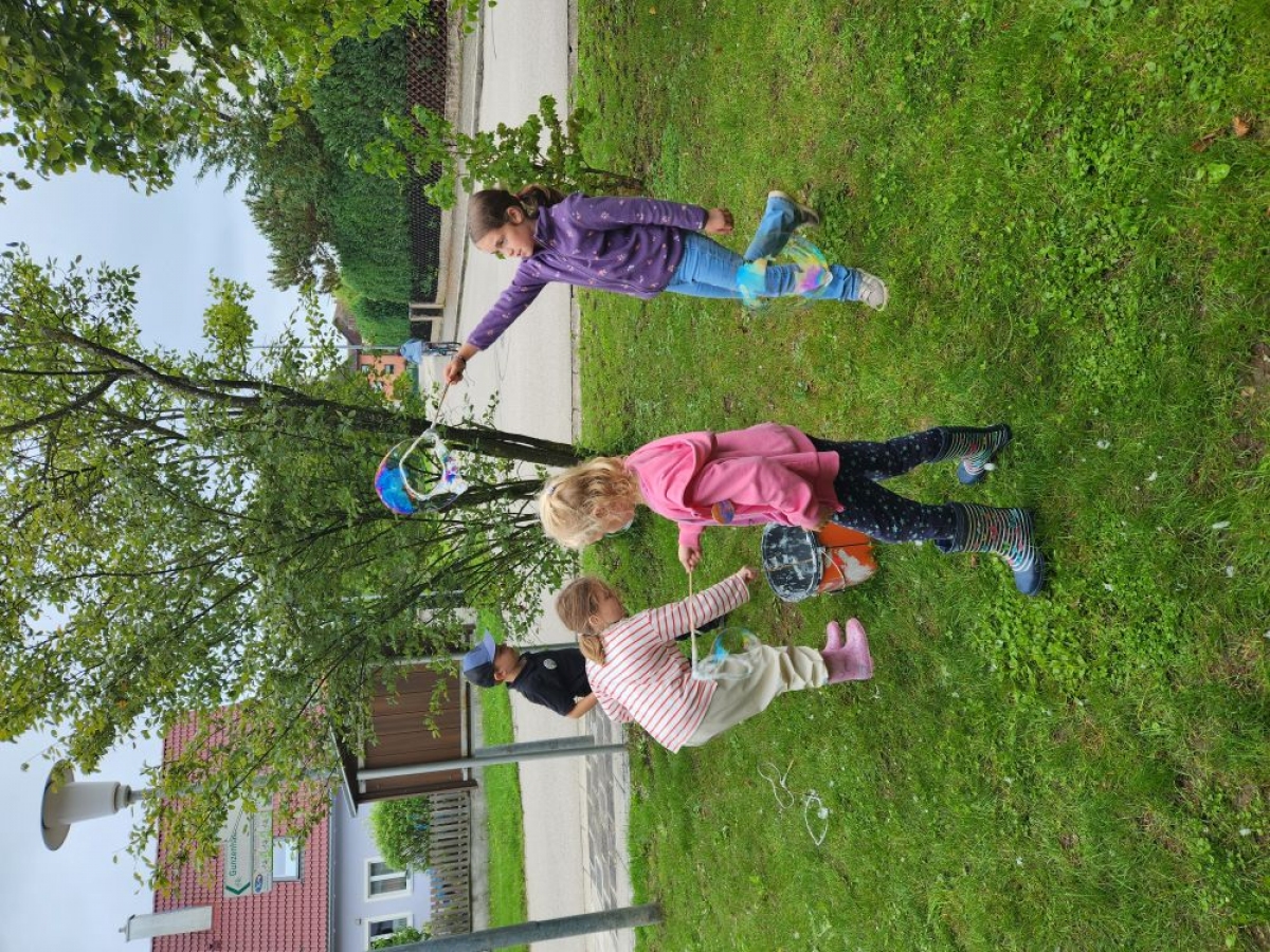 Kinder beim Spielen mit Seifenblasen
