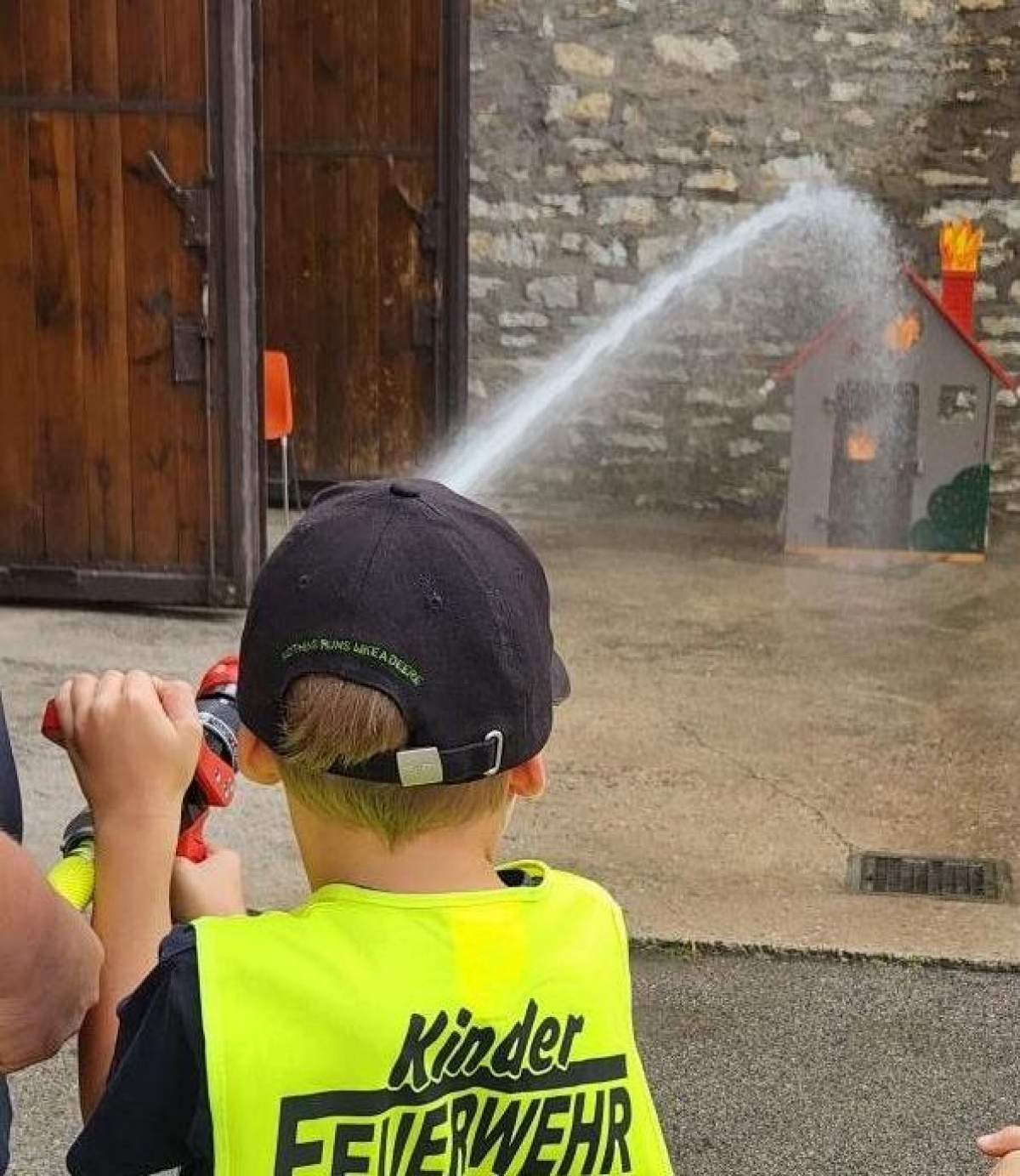 Kinder mit einem Feuerwehrschlauch